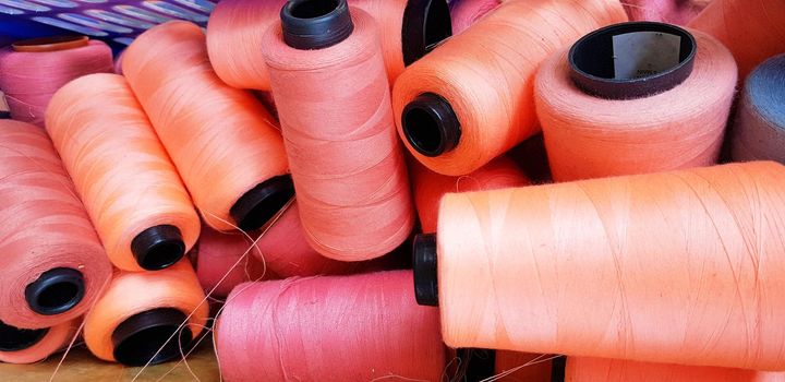 Colorful yarn on spool, yarn on tube, cotton, wool, linen thread orange