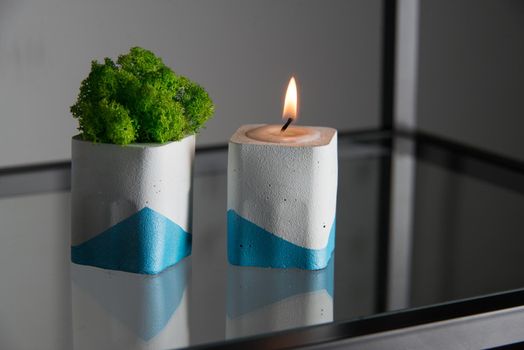 candle and moss in white and blue concrete candle holders.