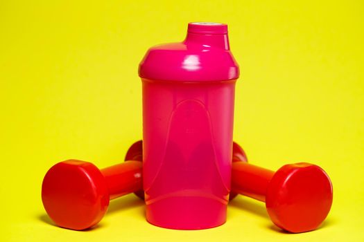 red dumbbells, pink shaker, colored background, sports, energy drink, gym equipment