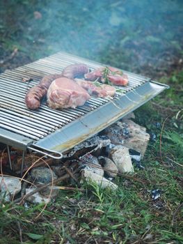 cooking pork meat in the grill outdoors with charcoal