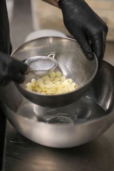chef making for icing a lilac drip cake in the professional kitchen lab