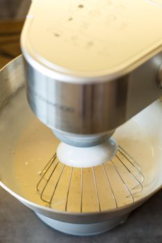 Beating cream for a sweet dessert in a food processor. Cream nozzle