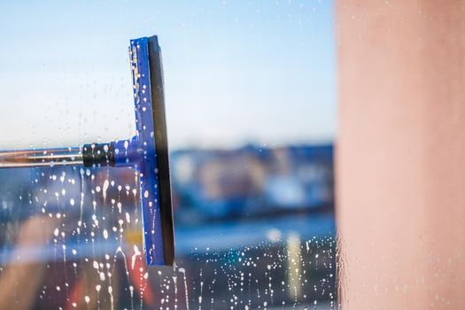 Window cleaning brush. Large window in a multi-storey building, cleaning service. Window cleaning in high-rise buildings, houses with a brush. Dust removal and glass washing.