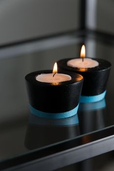 Candles in black and blue concrete candle holders.