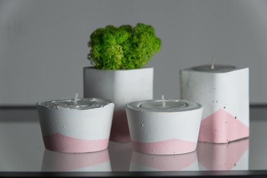 candles and moss in white and pink concrete candle holders.