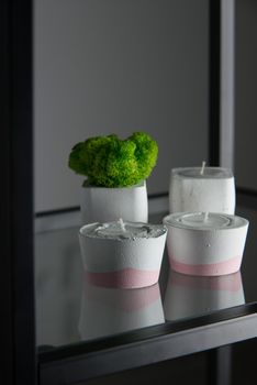 candles and moss in white and pink concrete candle holders.