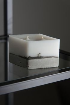 white candle on a concrete base.