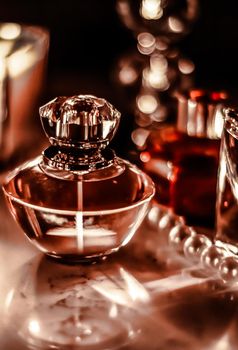 Perfumery, cosmetics branding and luxe concept - Perfume bottle and vintage fragrance on glamour vanity table at night, pearls jewellery and eau de parfum as holiday gift, luxury beauty brand present