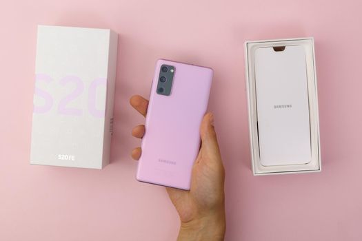 Tyumen, Russia-July 18, 2022: New Samsung s20 fe smartphone in a box. Top view, pink background