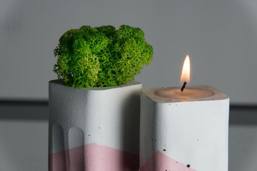 candle and moss in white and pink concrete candle holders.