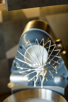 Beating cream for a sweet dessert in a food processor. Cream nozzle