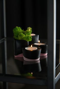 candles and moss in black and pink concrete candle holders.