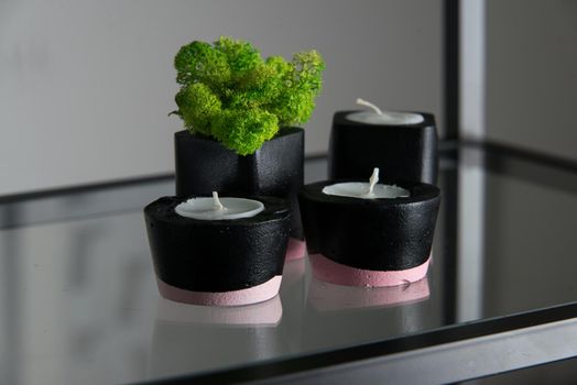 candles and moss in black and pink concrete candle holders.