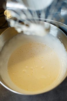 Beating cream for a sweet dessert in a food processor. Cream nozzle