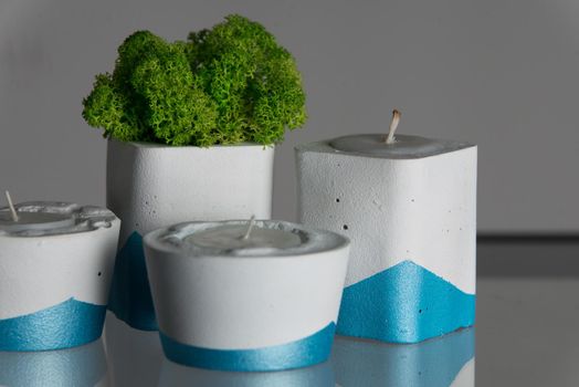 candles and moss in white and blue concrete candle holders.