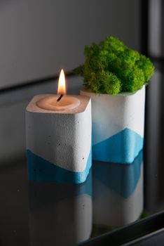 candle and moss in white and blue concrete candle holders.