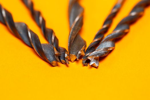 Drills for wood of different sizes for a drill on an orange background. Construction tool