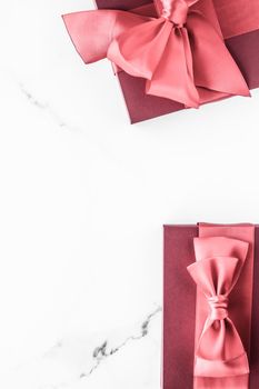 Birthday, wedding and girly branding concept - Coral gift box with silk bow on marble background, girl baby shower present and glamour fashion gift for luxury beauty brand, holiday flatlay art design