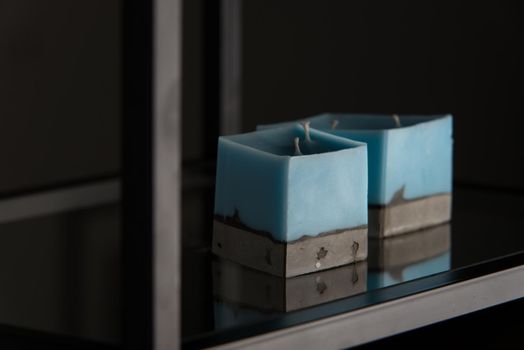 blue candle on a gray concrete base.