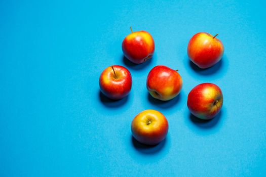 red-yellow juicy apples on a blue background. Healthy Nutrition and Vitamins