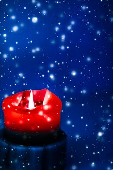 Happy holidays, greeting card and winter season concept - Red holiday candle on blue sparkling snowing background, luxury branding design for Christmas, New Years Eve and Valentines Day