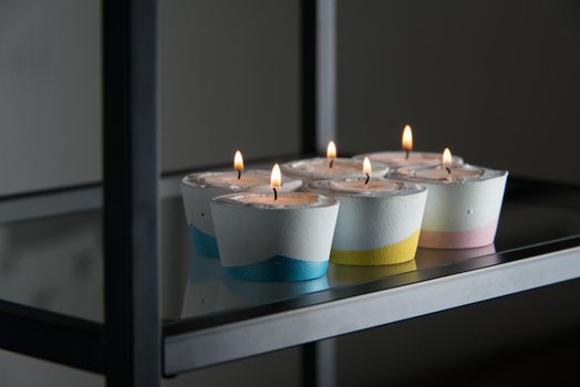 candles in a differen colours concrete candle holders.