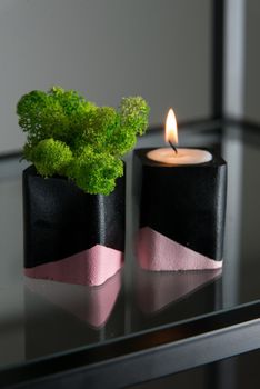 candle and moss in black and pink concrete candle holders.