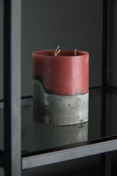 red candle on a gray concrete base.