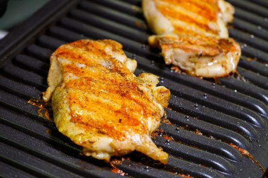 grilled chicken with spices on the electric grill in the home kitchen