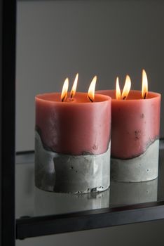 red candle on a gray concrete base.