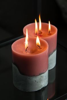 red candle on a gray concrete base.