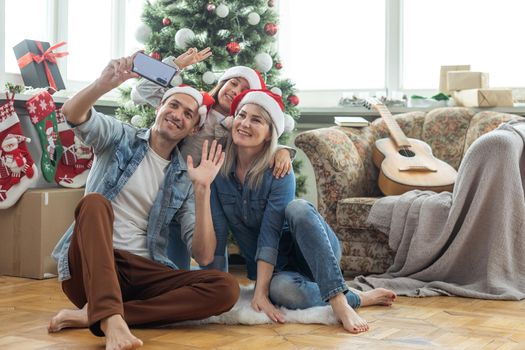 Christmas. Family. Happiness. dad, mom and daughter in Santa hats looking at camera and smiling