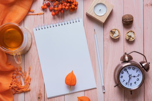 Blank sheet of paper, alarm clock and autumn cozy decor top view. Copy space for autumn text.