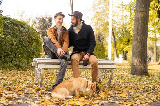 Father and son with a pet on a walk in the autumn park.