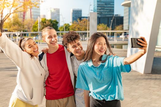 Cheerful young people taking group selfie on the city street during sunset. Asian, Latin, Caucasian and Arab, multicultural friends. High quality photo