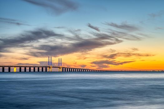 The famous Oeresund bridge after sunset with the lights of Copenhagen in the distance