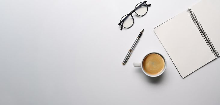 Top view empty notebook, eyeglasses and coffee cup on white background.