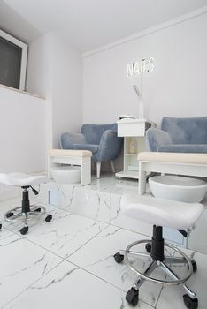 Interior of white modern manicure salon without people. Luxury work places for masters of pedicure