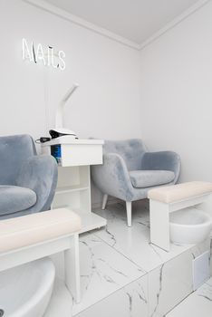 Interior of white modern manicure salon without people. Luxury work places for masters of pedicure