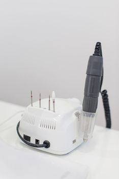 Manicure Studio. White lamp on white table with nail tool