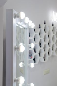 Make up mirror with light bulbs, backstage makeup room. shelves in the form of honeycombs on a background