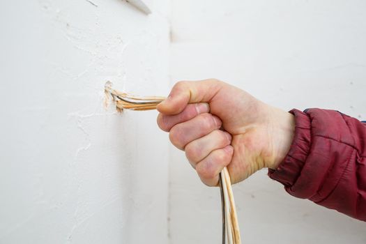 Electricity installation. During repair. open the wires. Sticking out isolated on a white wall. Professional installation electrically