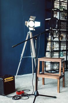 studio condenser microphone with pop filter and anti-vibration mount live recording. Blue wall, speaker and decorative light on a background.