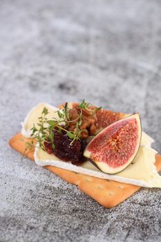 Cracker with a slice of camembert, jam, figs and nuts.
A great snack idea for a holiday, picnic or party.
