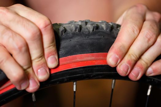 A man changes the camera on a bicycle wheel. Spike Bike Chamber