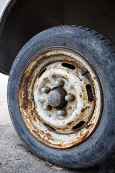 Rusty wheel with a tire from a car. Abandoned car tire.