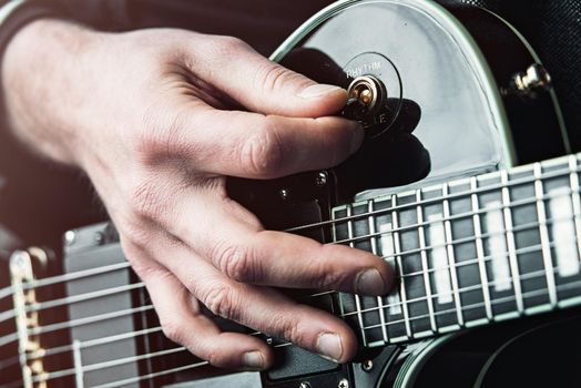 Close up shot of Hands of man playing electric guitar.