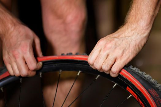A man changes the camera on a bicycle wheel. Spike Bike Chamber