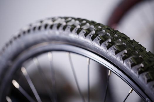 Black rubber tire with spikes for a bicycle wheel. Bike accessories