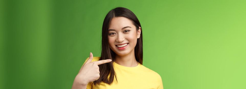 Close-up joyful proud asian assertive girl introduce herself, pointing own face smiling joyfully, boastful telling own achievement, bragging accomplishment, assure can deal with work.